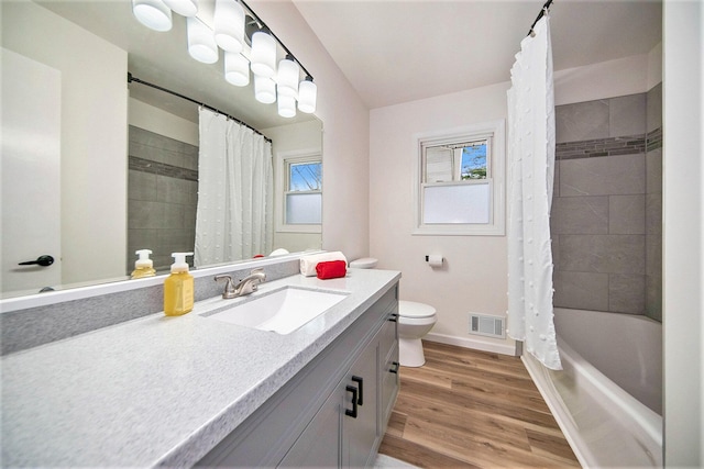 full bathroom featuring hardwood / wood-style flooring, vanity, a wealth of natural light, and toilet