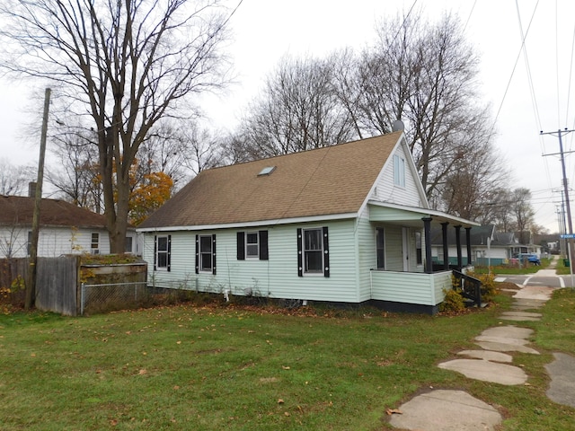 rear view of house with a lawn and covered porch