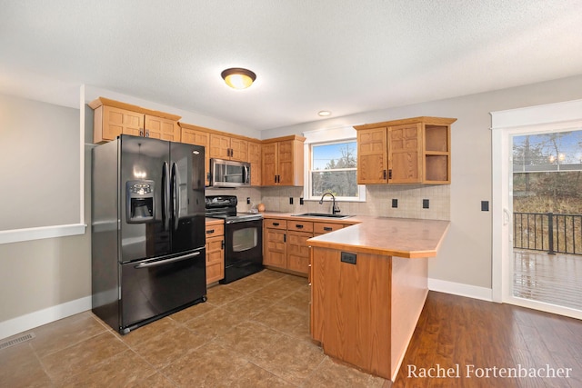 kitchen with kitchen peninsula, tasteful backsplash, stainless steel appliances, sink, and a breakfast bar area