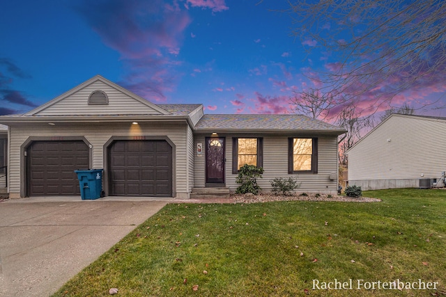 single story home with central AC, a yard, and a garage