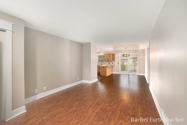 unfurnished living room featuring dark hardwood / wood-style flooring and sink