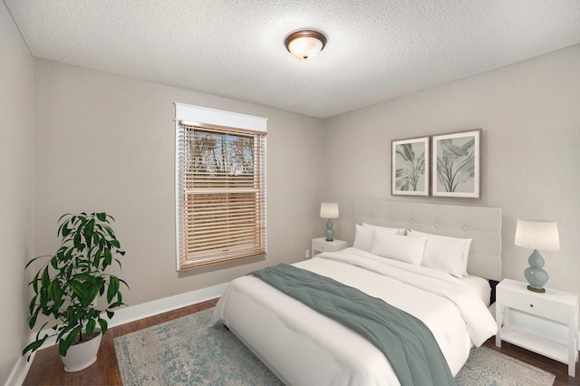 bedroom with a textured ceiling and dark hardwood / wood-style floors