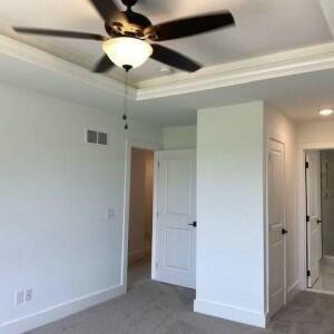 empty room featuring a raised ceiling and ceiling fan