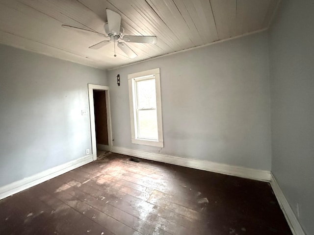 empty room with ceiling fan, dark hardwood / wood-style flooring, and wooden ceiling