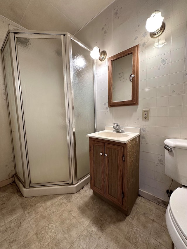 bathroom featuring vanity, toilet, and a shower with shower door