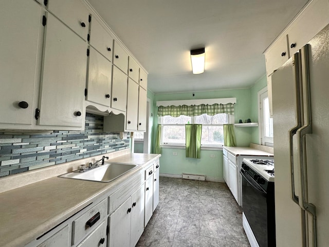 kitchen with white appliances, white cabinetry, and sink