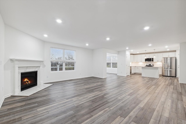 unfurnished living room with a fireplace and light hardwood / wood-style floors