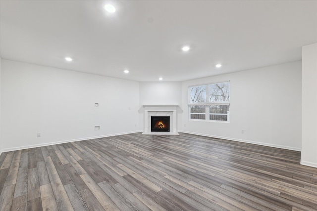 unfurnished living room featuring a fireplace and dark hardwood / wood-style floors