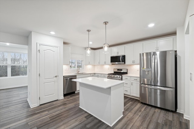 kitchen with white cabinets, sink, stainless steel appliances, and hanging light fixtures