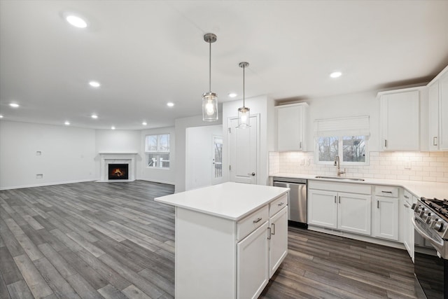 kitchen featuring white cabinets, stainless steel appliances, a healthy amount of sunlight, and sink