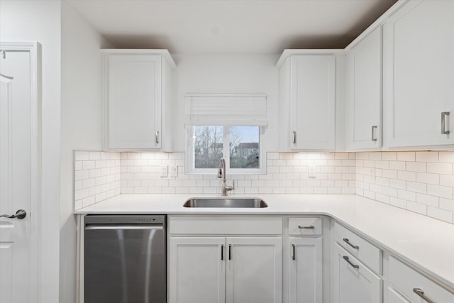 kitchen featuring backsplash, white cabinetry, sink, and stainless steel dishwasher