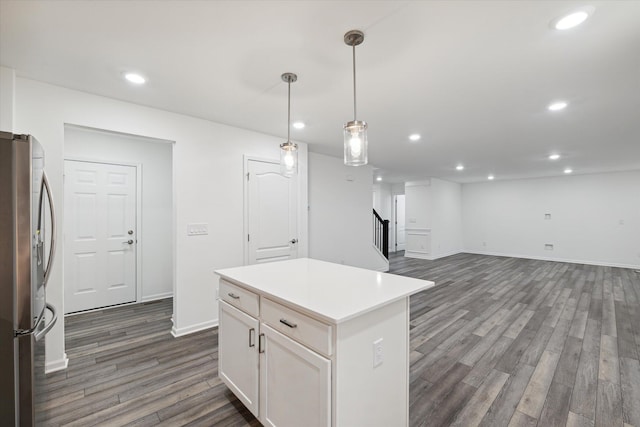 kitchen with pendant lighting, white cabinets, a kitchen island, dark hardwood / wood-style flooring, and stainless steel refrigerator