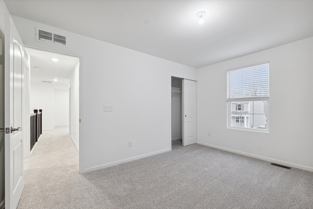 unfurnished bedroom with light carpet and a closet