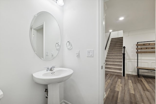 bathroom with hardwood / wood-style flooring and crown molding