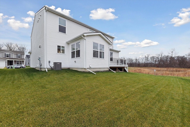 rear view of property featuring central AC and a yard