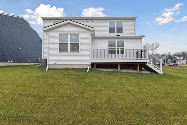 back of property with a wooden deck, a yard, and central AC unit