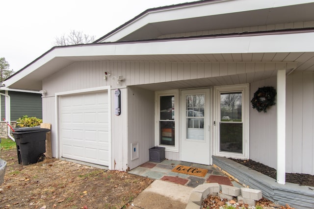 doorway to property featuring a porch and a garage