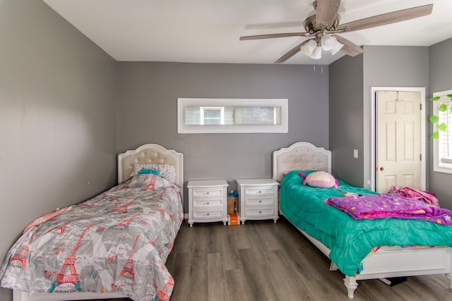 bedroom with a closet, multiple windows, ceiling fan, and dark hardwood / wood-style flooring