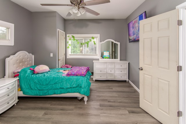 bedroom with dark hardwood / wood-style flooring and ceiling fan