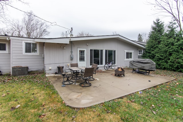 back of house with a fire pit, a patio area, and a lawn