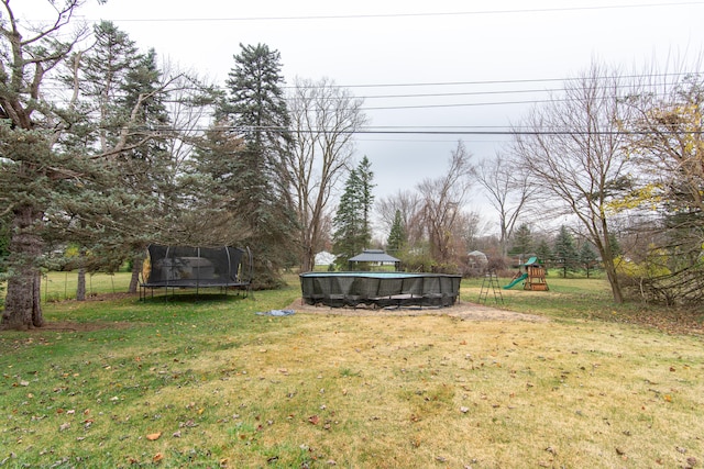 view of yard featuring a playground and a trampoline