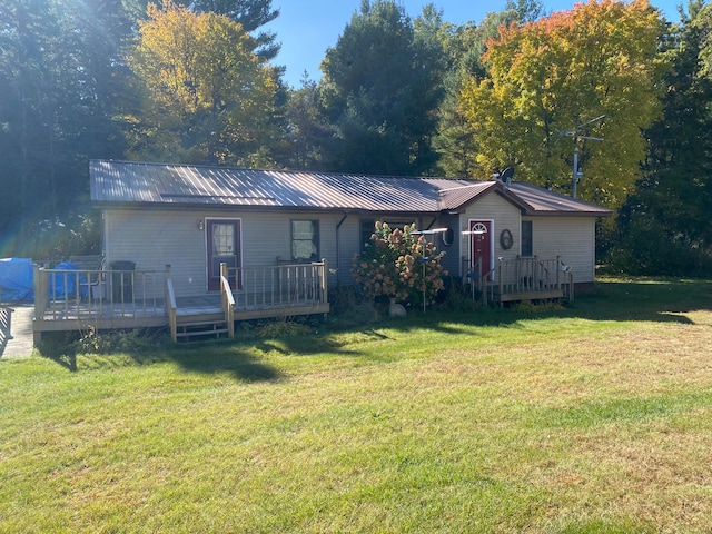 view of front facade with a wooden deck and a front yard