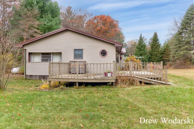 rear view of property with a lawn and a deck