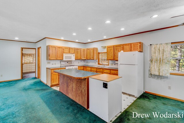 kitchen featuring a center island, white appliances, sink, ornamental molding, and light colored carpet