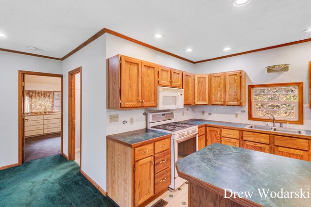 kitchen with dark colored carpet, white appliances, crown molding, and sink