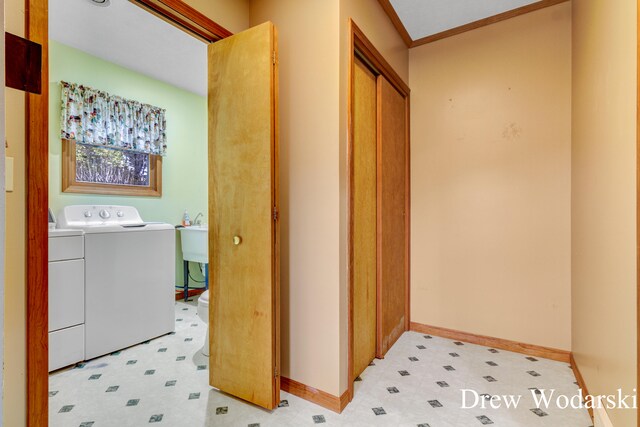 laundry area with crown molding and washing machine and clothes dryer