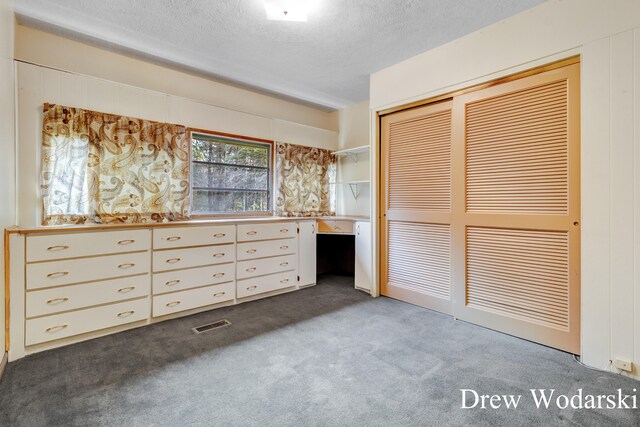 unfurnished bedroom featuring carpet flooring, a textured ceiling, and a closet