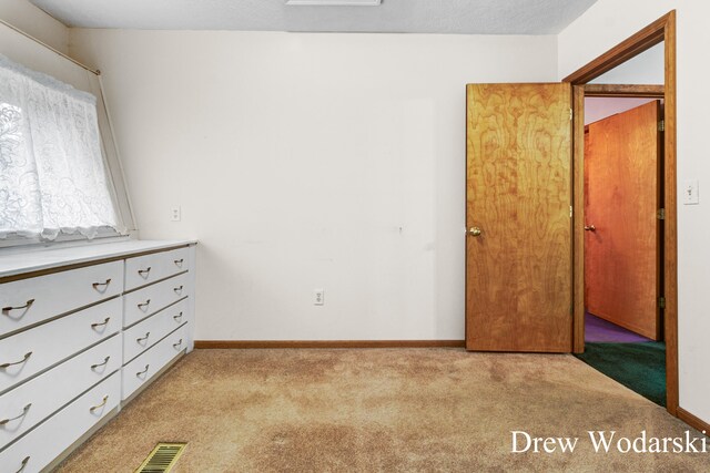 unfurnished bedroom featuring light carpet