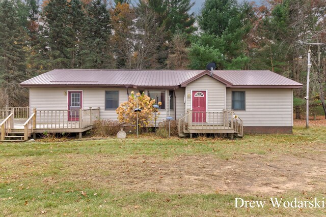 view of front facade featuring a wooden deck and a front yard