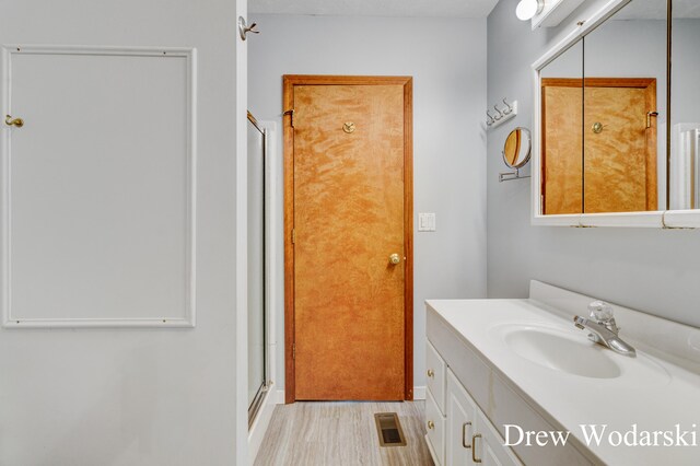 bathroom with vanity and a shower with shower door