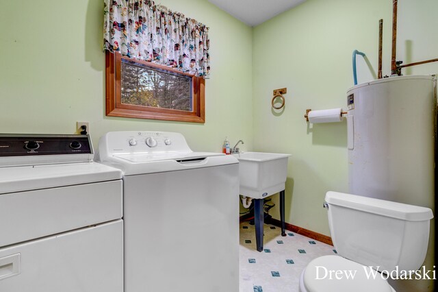 washroom with water heater and washer and dryer