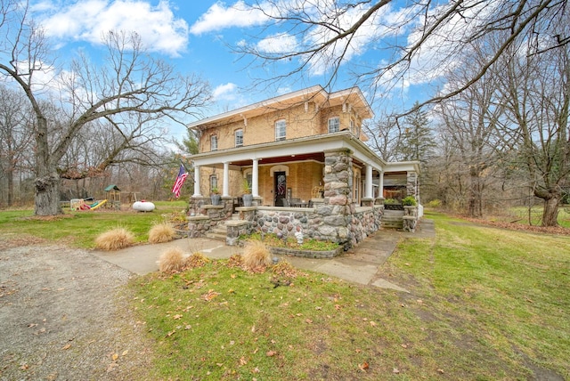 view of front facade featuring covered porch and a front yard