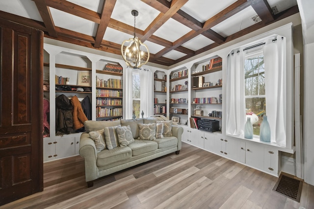 sitting room with coffered ceiling, built in features, beamed ceiling, wood-type flooring, and a chandelier