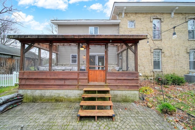 rear view of house featuring a sunroom and central air condition unit