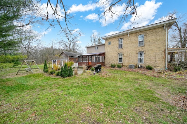 back of house with a yard, central AC, and a sunroom