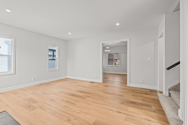 unfurnished living room featuring plenty of natural light and light hardwood / wood-style floors