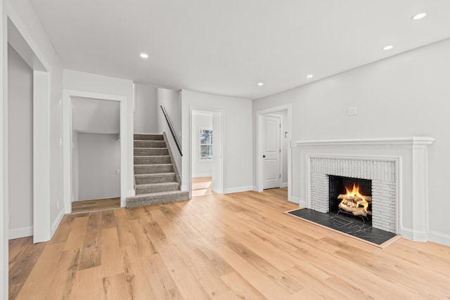 unfurnished living room featuring a fireplace and light hardwood / wood-style floors