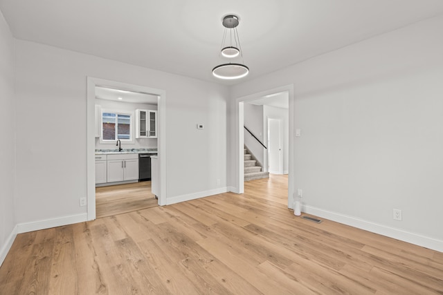 unfurnished dining area with light wood-type flooring and sink