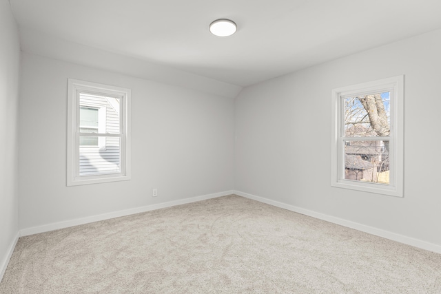 carpeted empty room featuring a healthy amount of sunlight and lofted ceiling