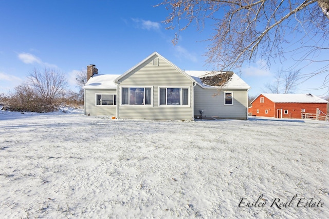 snow covered property featuring a chimney