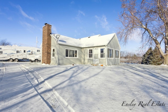 snow covered property featuring a chimney