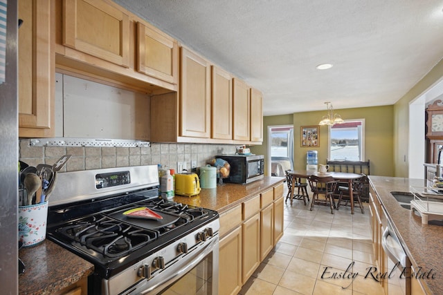 kitchen featuring stainless steel appliances, light tile patterned floors, decorative light fixtures, decorative backsplash, and a chandelier