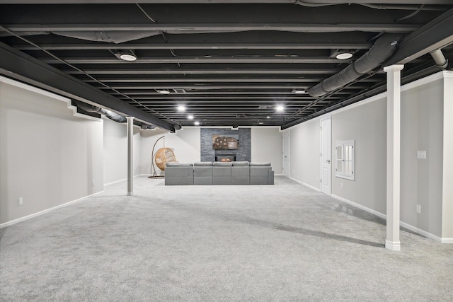 basement with a large fireplace and carpet floors