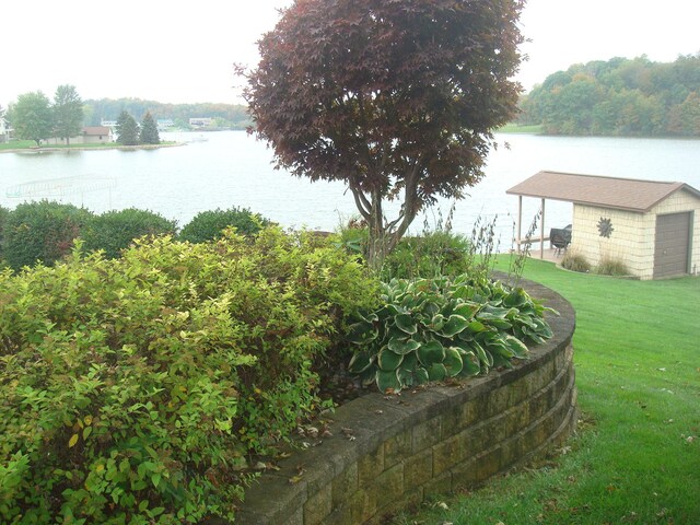 view of yard featuring a water view and an outbuilding