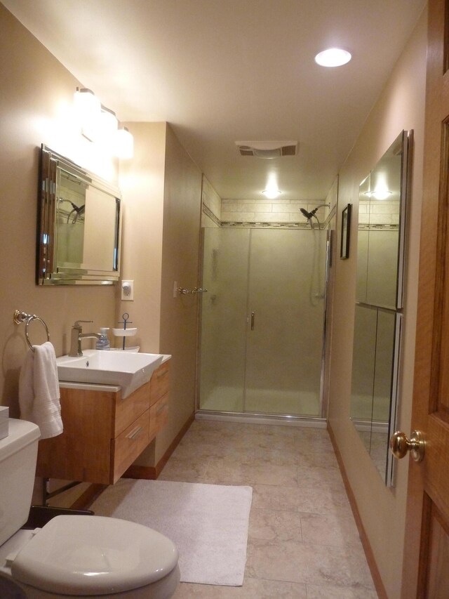 bathroom featuring vanity, toilet, and a shower with door