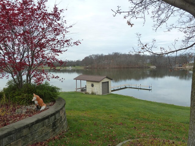 dock area with a lawn and a water view